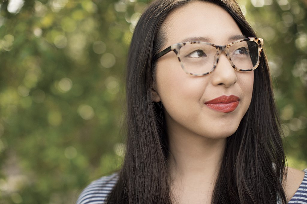 A woman with glasses smiling