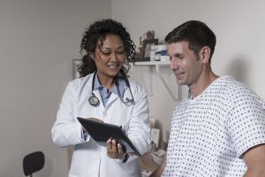 Doctor showing test results to patient in hospital room