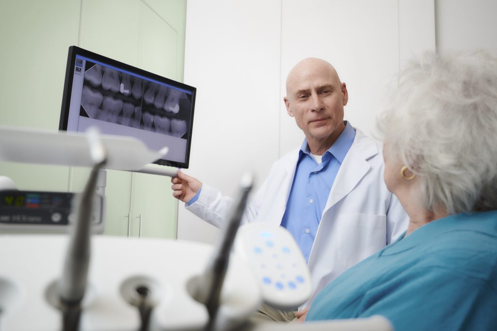 A dentist and patient discussing a dental x-ray