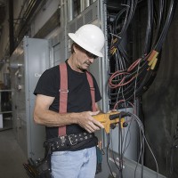 A man in a warehouse looking at electrical equipment